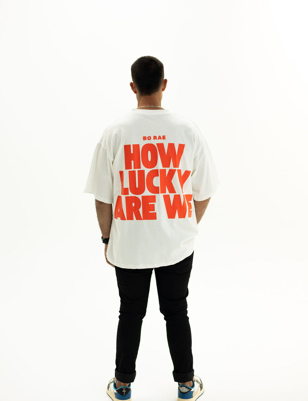 Back view of BO RAE How Lucky Are We oversized unisex adult T-shirt in white featuring large Red graphic print