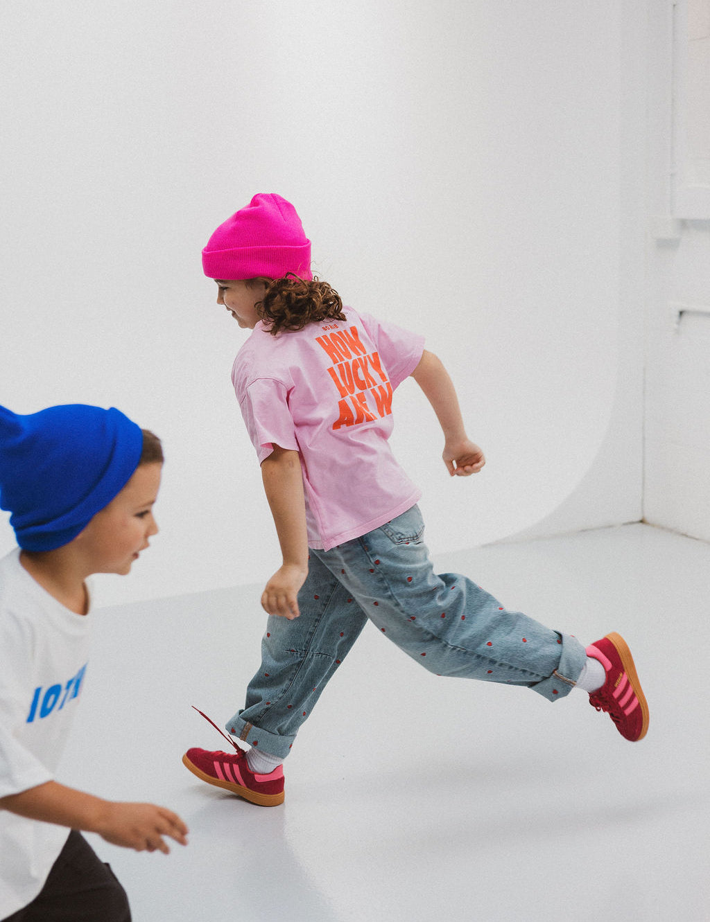 Child wearing BO RAE How Lucky Are We oversized kids T-shirt in pink while running.