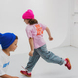 Child wearing BO RAE How Lucky Are We oversized kids T-shirt in pink while running.