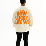 Back view of BO RAE How Lucky Are We oversized unisex adult jumper in Beige featuring large orange graphic print